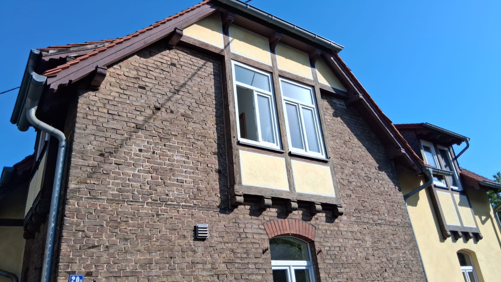 Denkmalgeschützte Fassade in Frankfurt am Main, sanierter Fachwerk-Giebel mit Backsteinsockel – ACG Bausanierung GmbH
